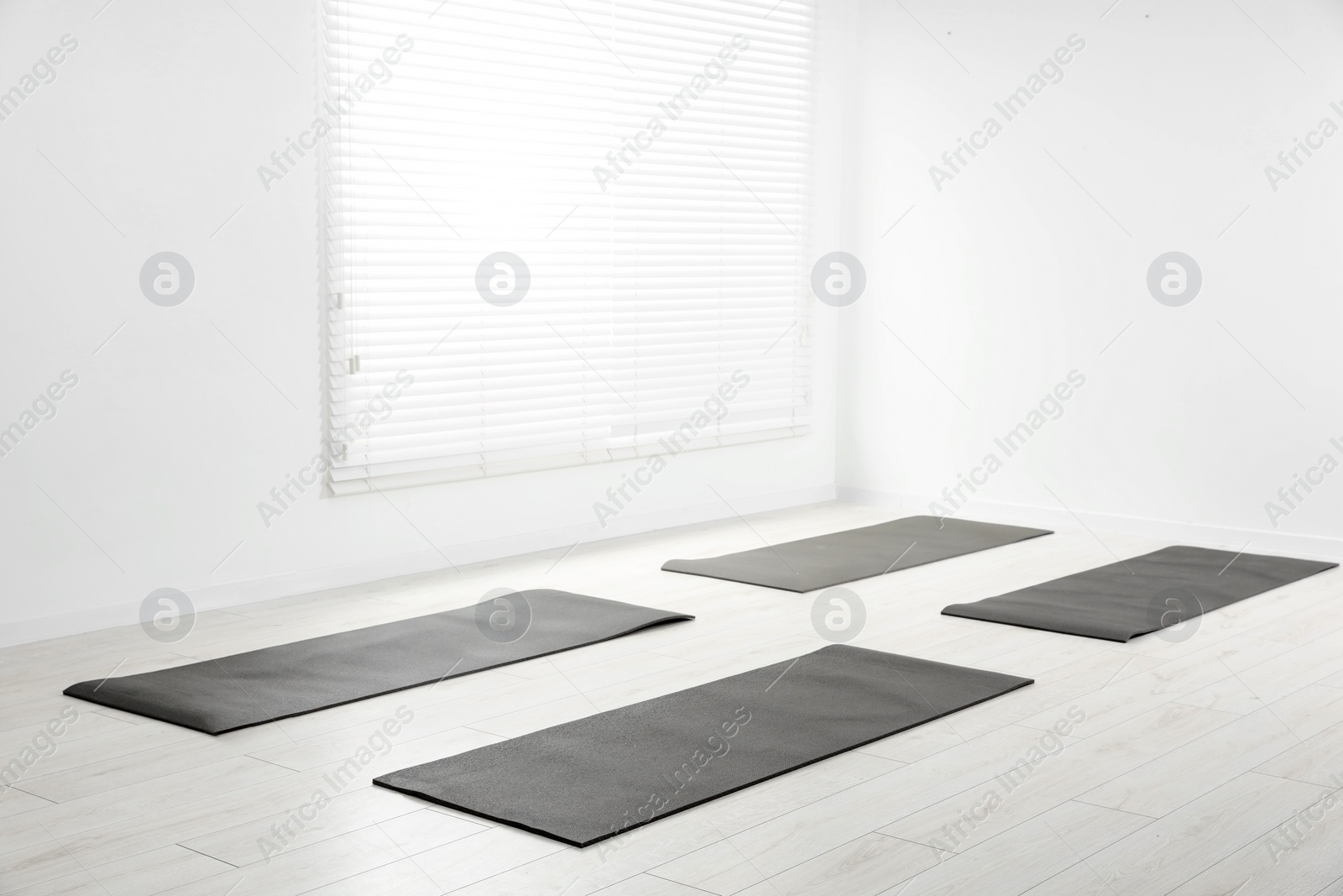 Photo of Spacious yoga studio with exercise mats. Space for text