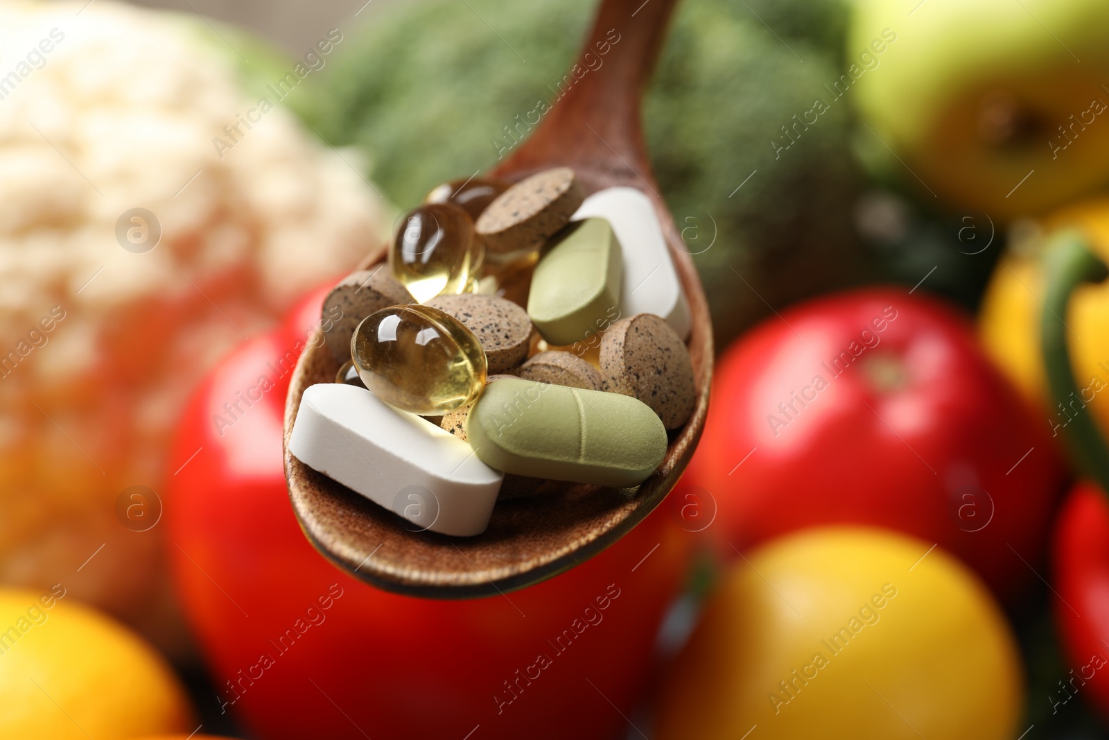 Photo of Dietary supplements. Spoon with different pills over food products, closeup