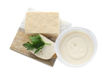 Photo of Tasty tofu, cream cheese and parsley leaf on white background, top view