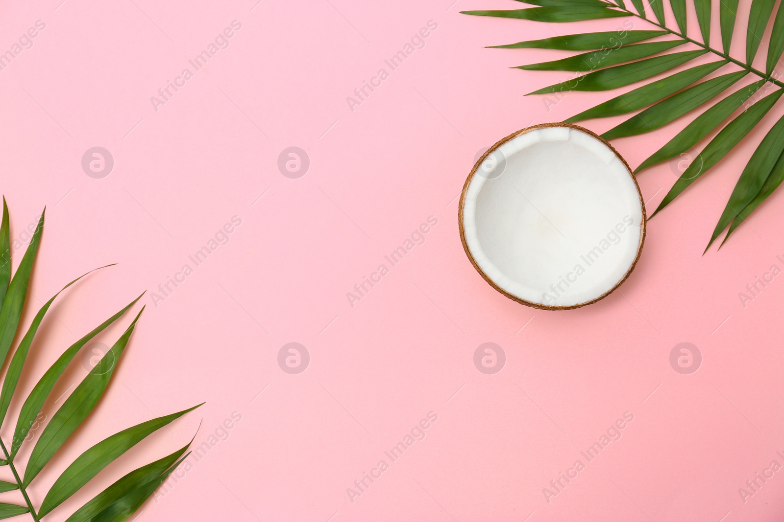 Photo of Fresh coconut and palm leaves on pink background, flat lay. Space for text