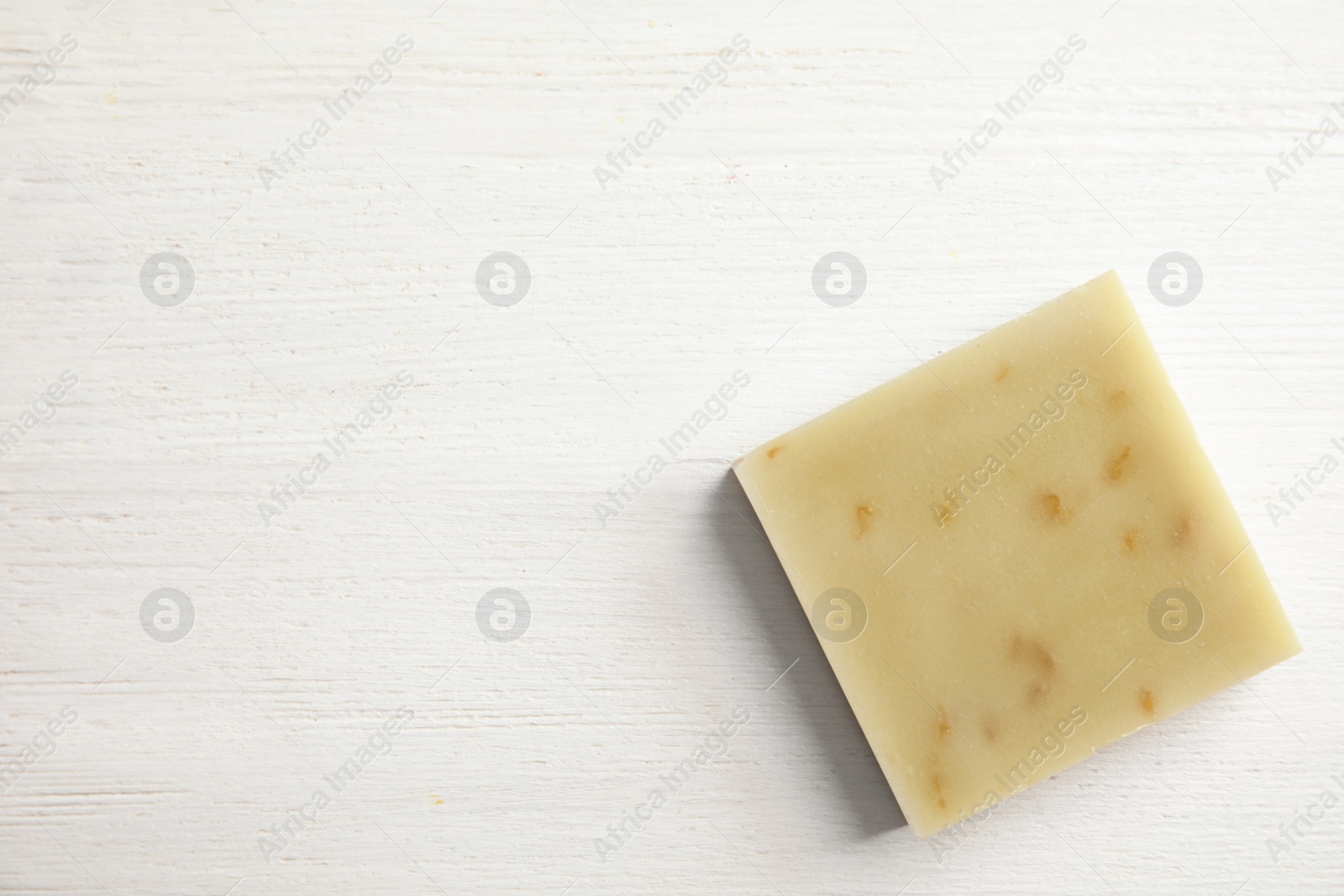 Photo of Hand made soap bar on white wooden background, top view. Space for text