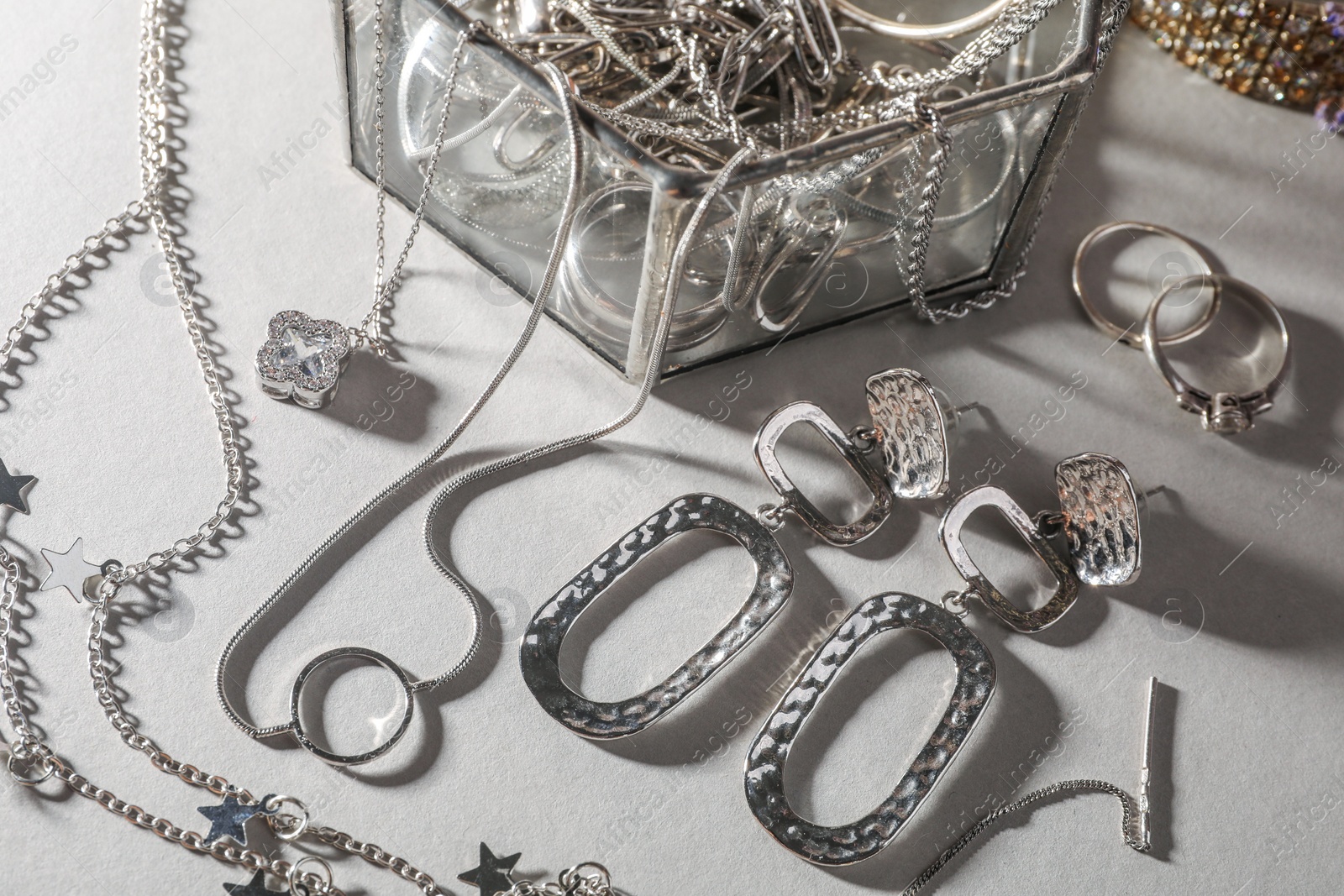 Photo of Metal chains and other different accessories on light table, above view. Luxury jewelry