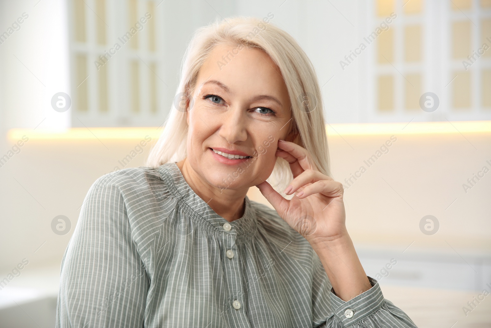 Photo of Portrait of beautiful mature woman in kitchen