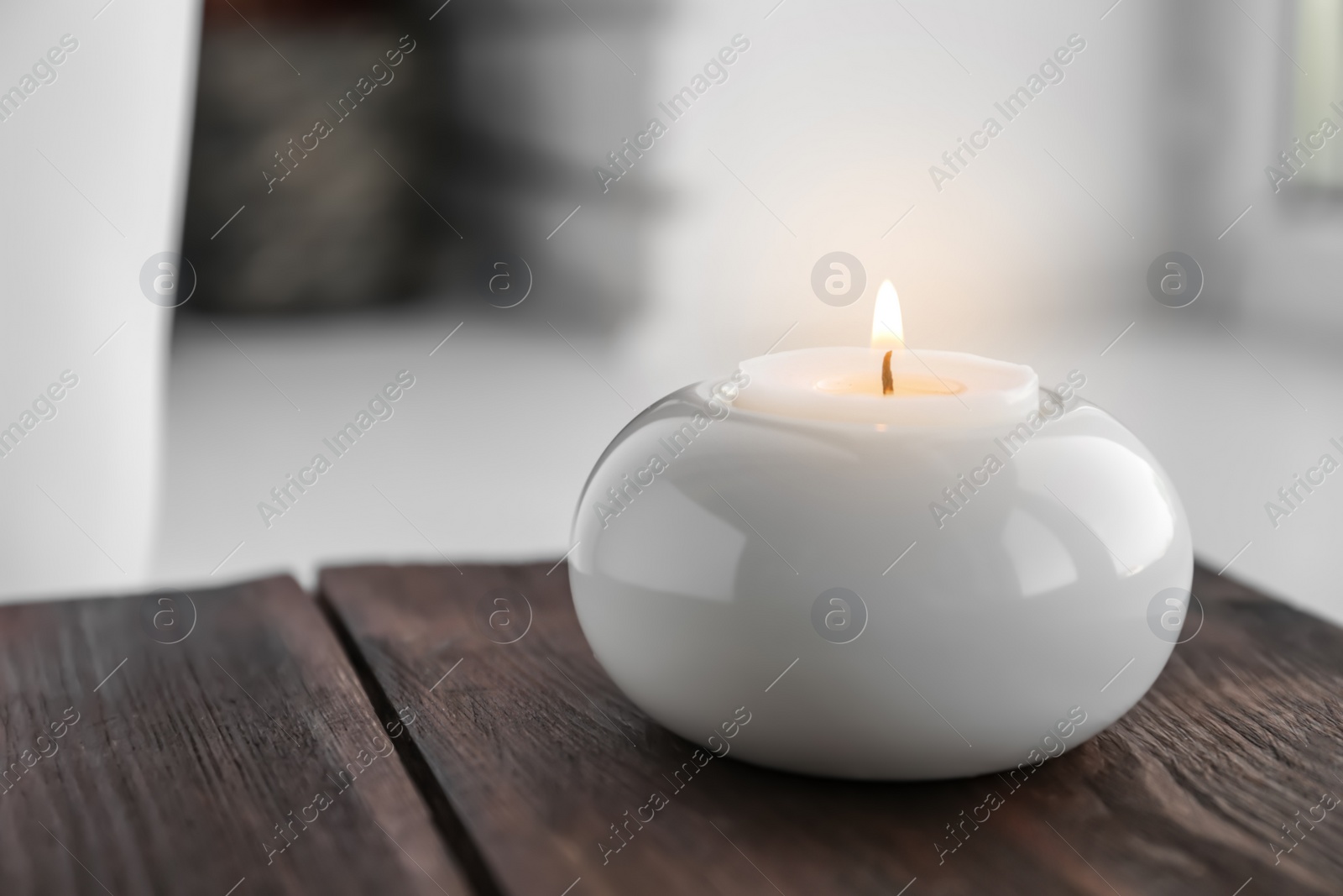 Photo of Beautiful burning wax candle in holder on table