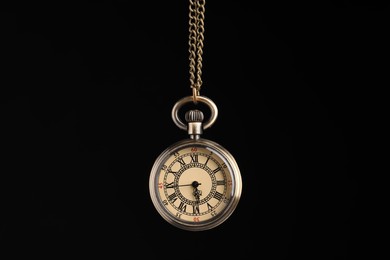 Photo of Beautiful vintage pocket watch with chain on black background. Hypnosis session