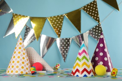 Photo of Colorful party hats and festive items on light blue background