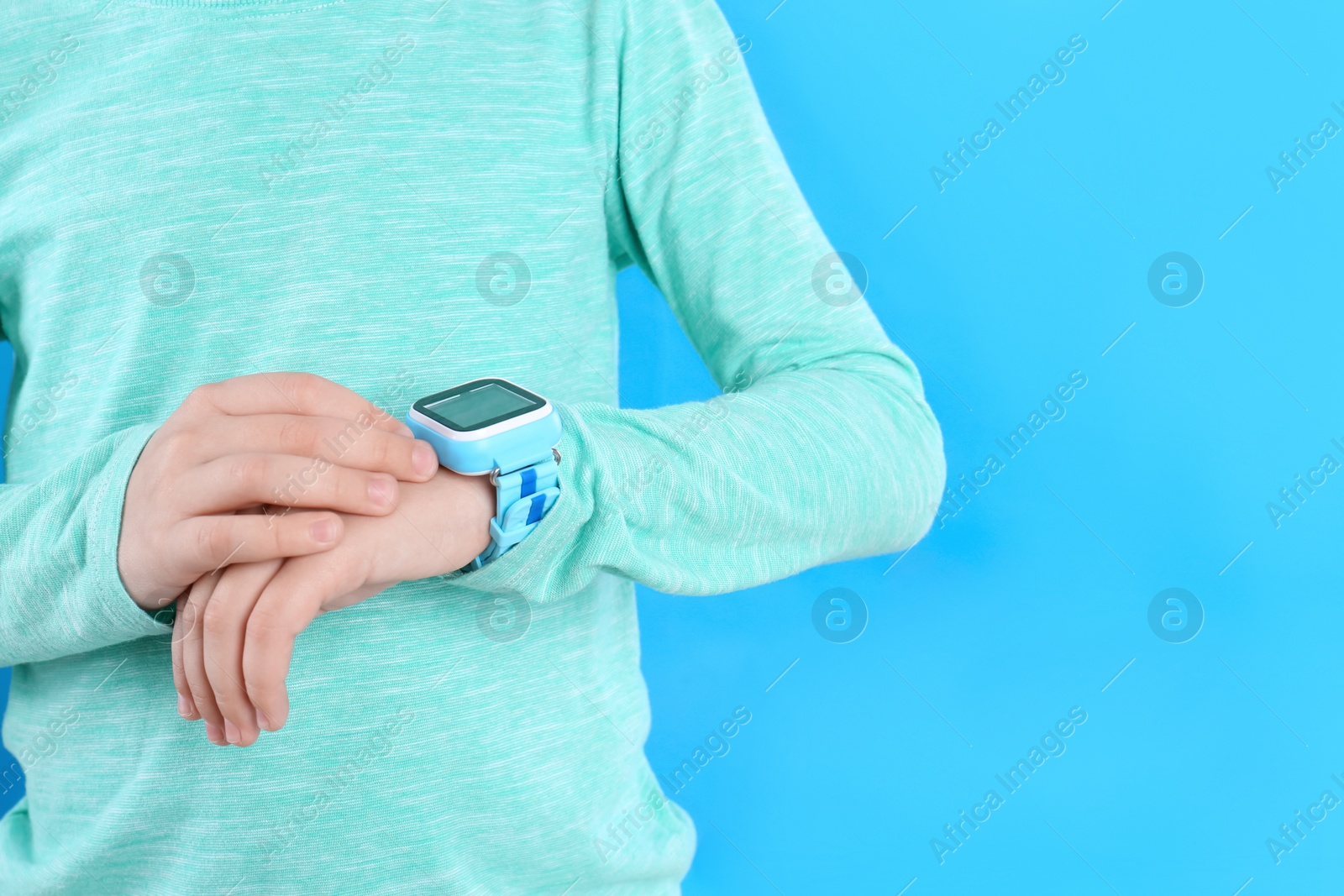 Photo of Boy with stylish smart watch on light blue background, closeup