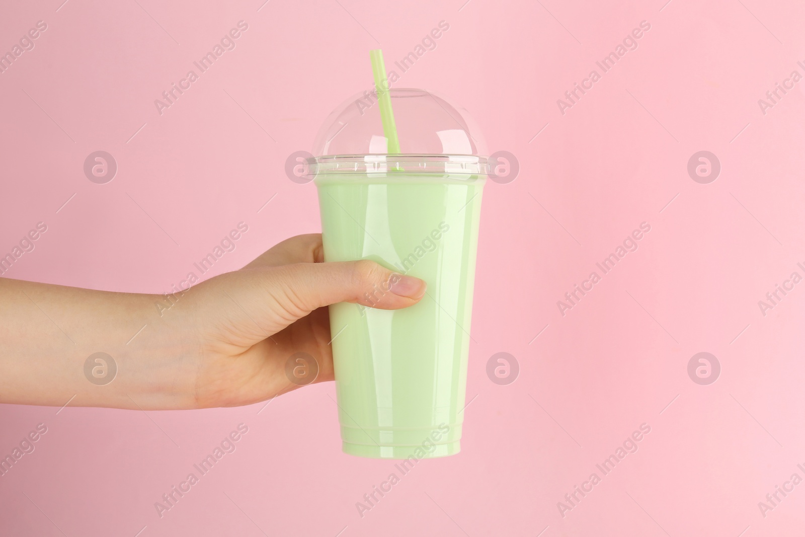 Photo of Woman with plastic cup of tasty smoothie on pink background, closeup