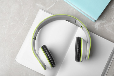 Photo of Modern headphones with hardcover books on grey background, top view