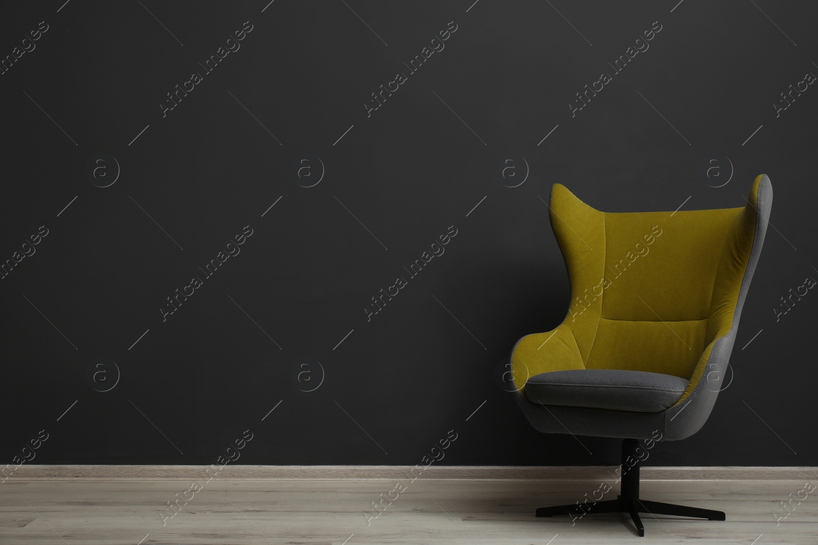 Photo of Comfortable office chair near black wall indoors. Space for text