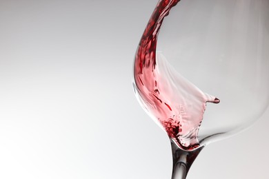 Tasty red wine in glass on white background, closeup. Space for text