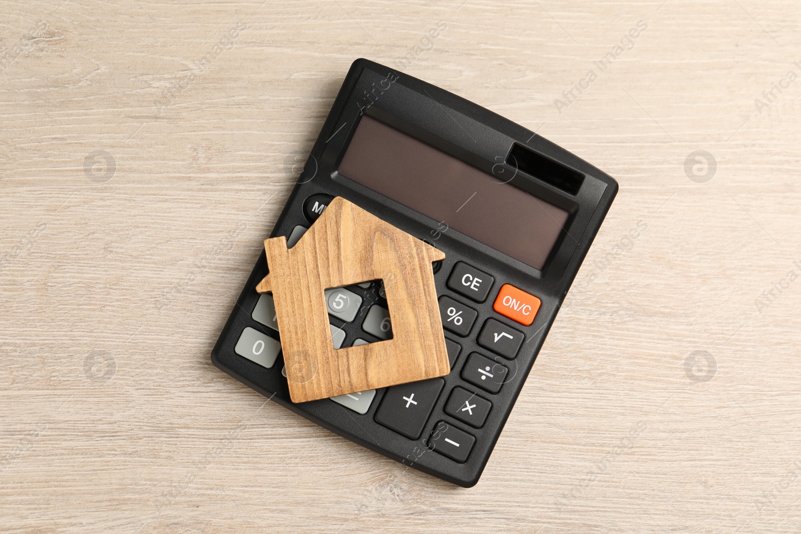 Photo of Mortgage concept. House model and calculator on wooden table, top view