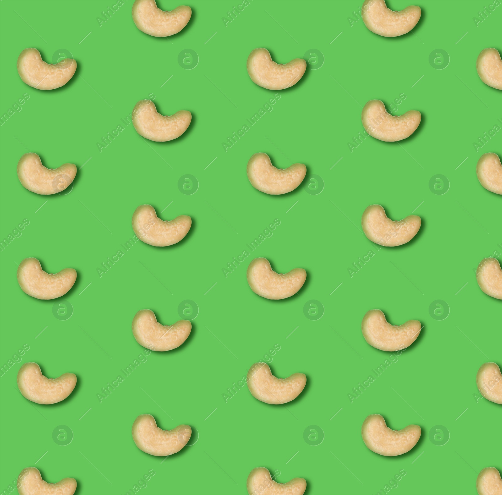 Image of Many tasty cashew nuts on green background, flat lay