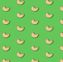 Image of Many tasty cashew nuts on green background, flat lay