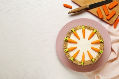 Flat lay composition with tasty carrot cake on white wooden table, space for text