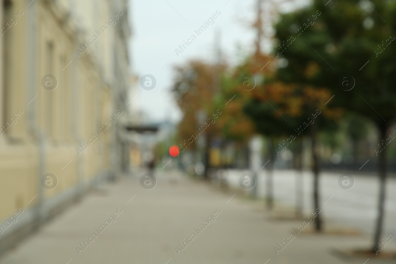 Photo of Blurred view of quiet street with beautiful buildings, sidewalk and trees