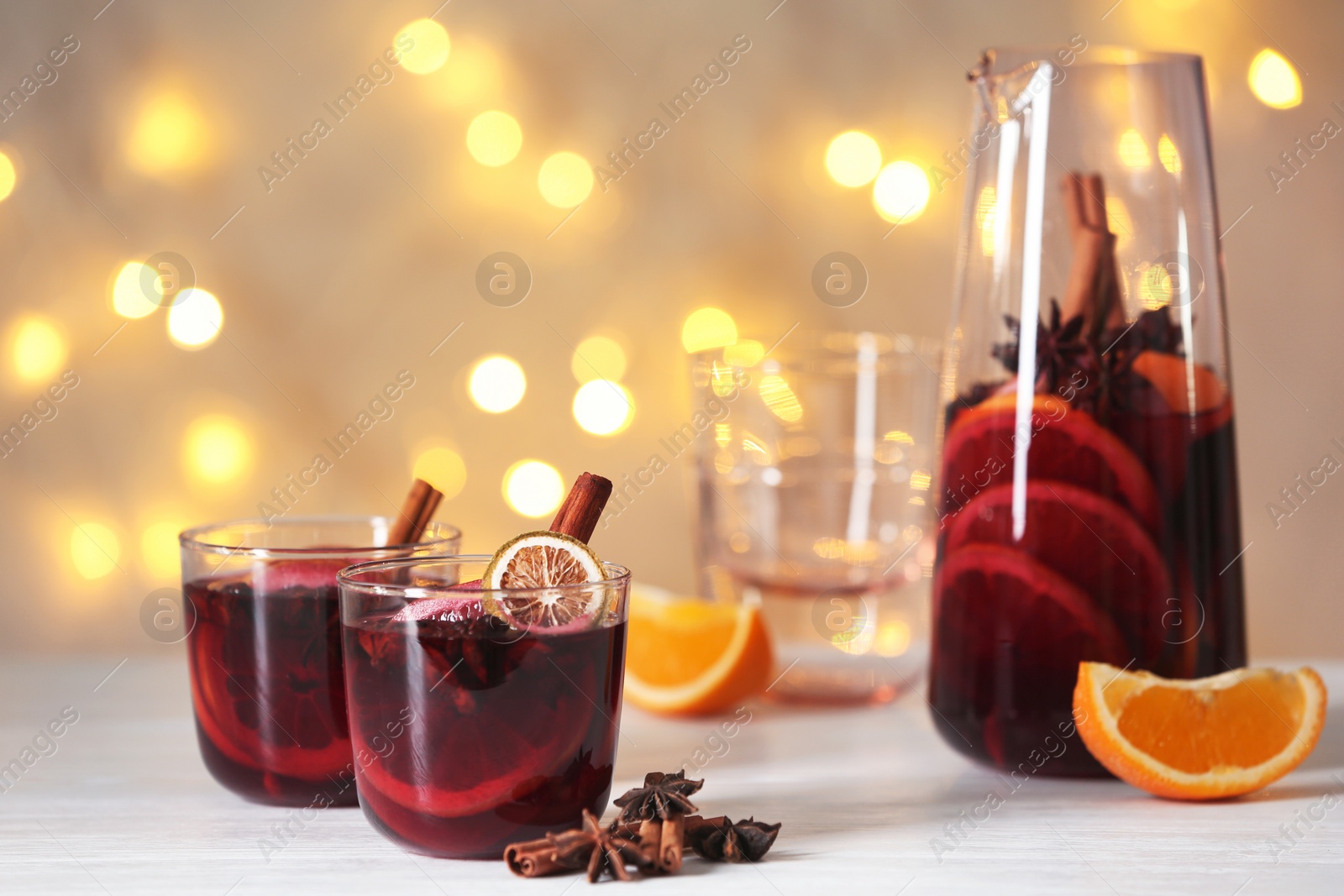 Photo of Mulled wine on table against blurred background. Space for text