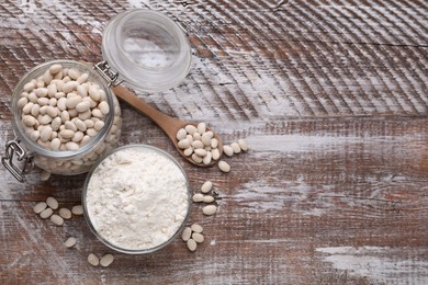 Photo of Bean flour and seeds on wooden table, flat lay. Space for text