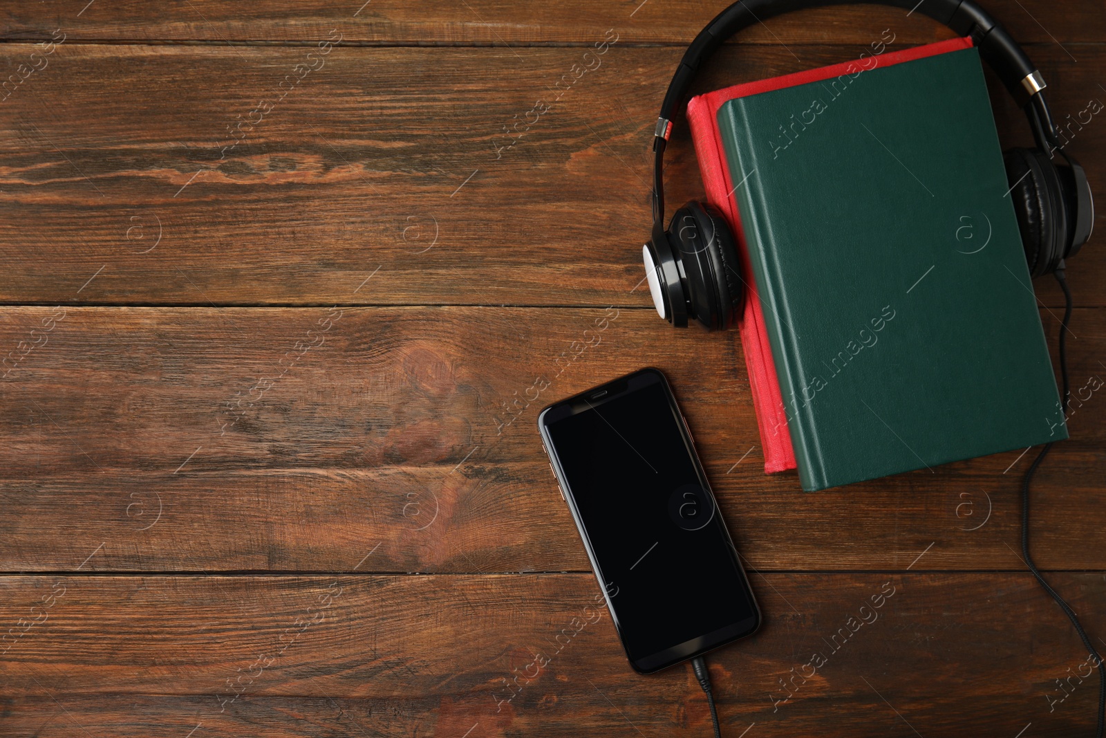 Photo of Books, mobile phone and headphones on wooden table, flat lay. Space for text