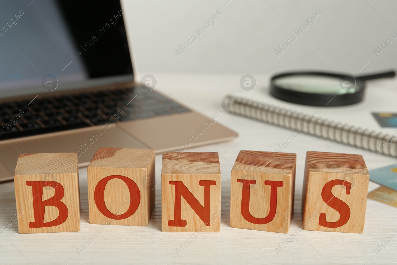 Image of Word Bonus made of wooden cubes with letters on office desk