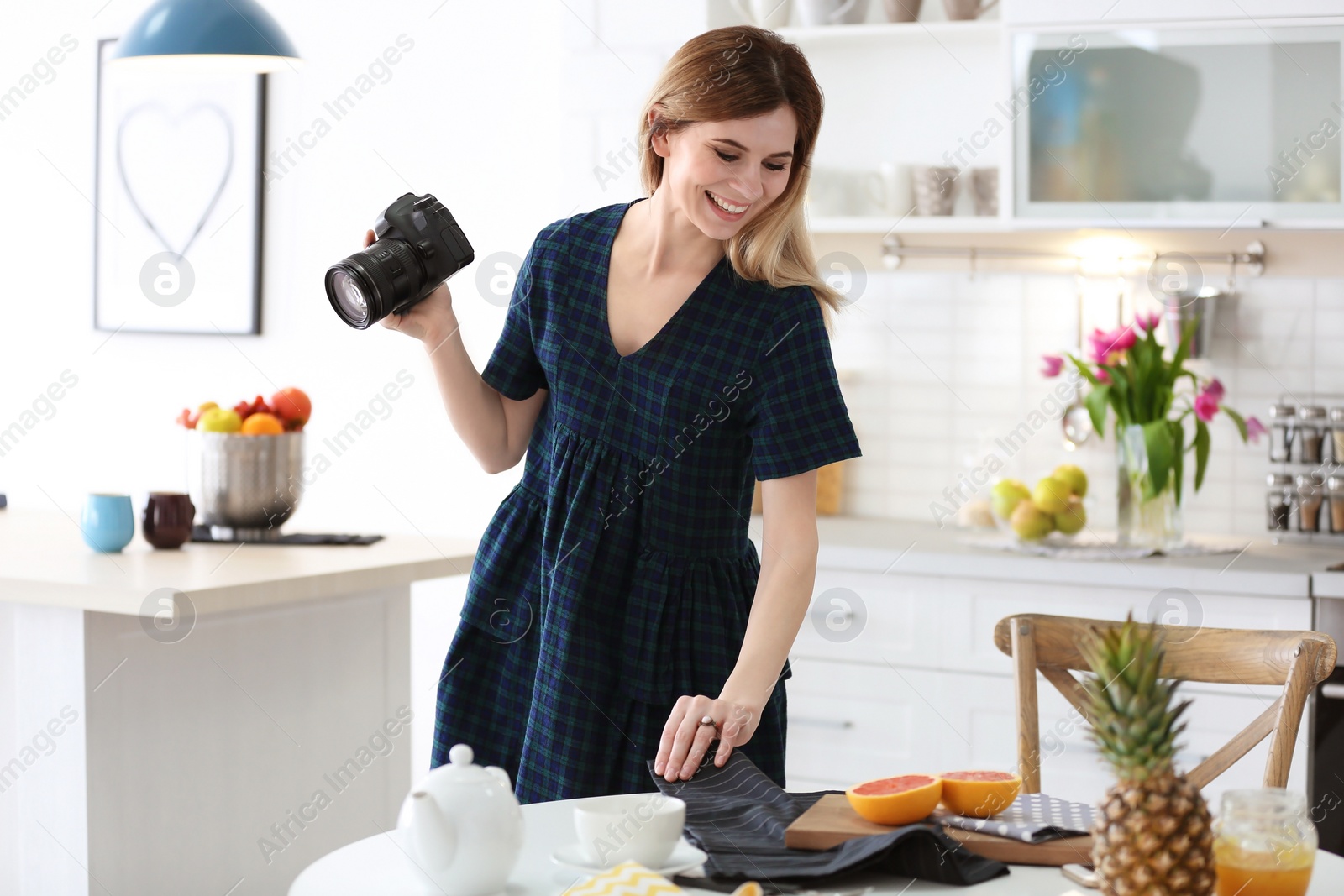 Photo of Young blogger taking photo of food in kitchen