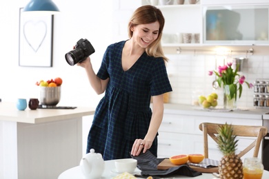 Young blogger taking photo of food in kitchen