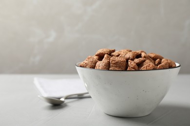 Photo of Sweet crispy corn pads in bowl and spoon on light table