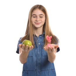 Photo of Teen girl with apple and candy on white background. Diabetes diet