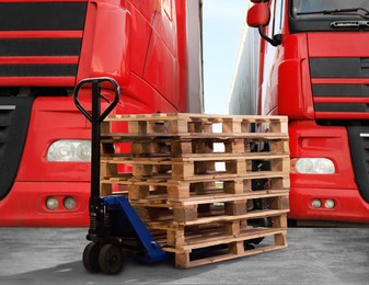 Image of Modern manual forklift with wooden pallets near trucks outdoors