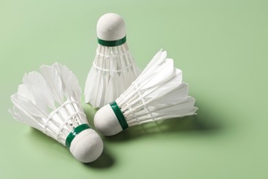 Feather badminton shuttlecocks on green background, closeup