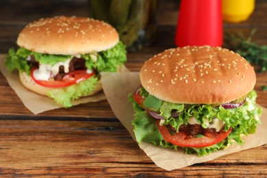 Photo of Delicious burgers with beef patty on wooden table, space for text