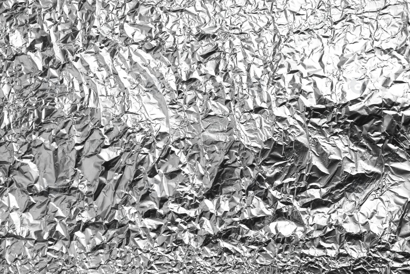 Photo of Crumpled silver foil as background, closeup view