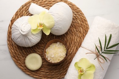 Flat lay composition with spa products and beautiful flowers on white marble table