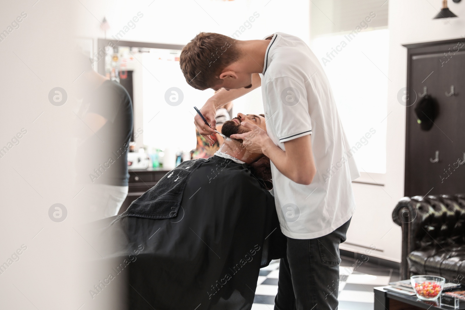 Photo of Professional barber working with client in hairdressing salon. Hipster fashion