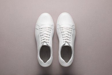 Photo of Pair of stylish white sneakers on grey background, top view