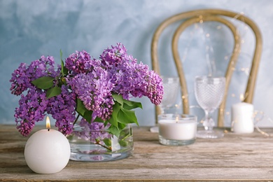 Photo of Vase with blossoming lilac on table indoors. Spring flowers