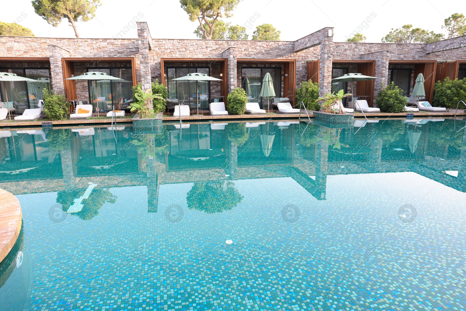 Photo of Outdoor swimming pool with umbrellas and sunbeds at resort