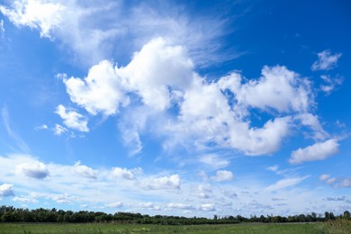 Photo of Beautiful view on blue sky with white clouds above green field