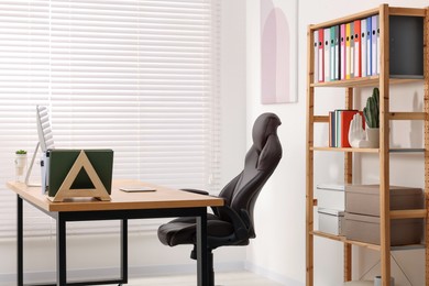Photo of Desk and comfortable chair in modern office. Interior design