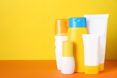 Photo of Different suntan products on color background. Space for text