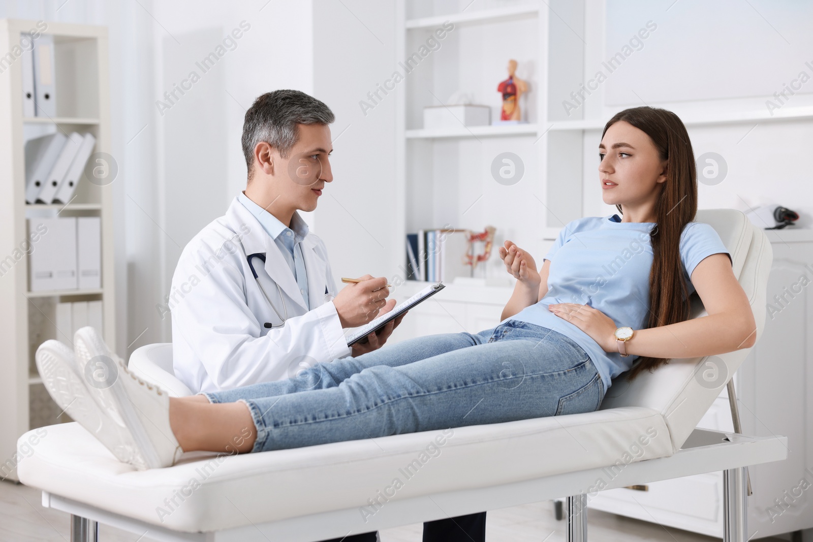 Photo of Gastroenterologist with clipboard consulting patient in clinic