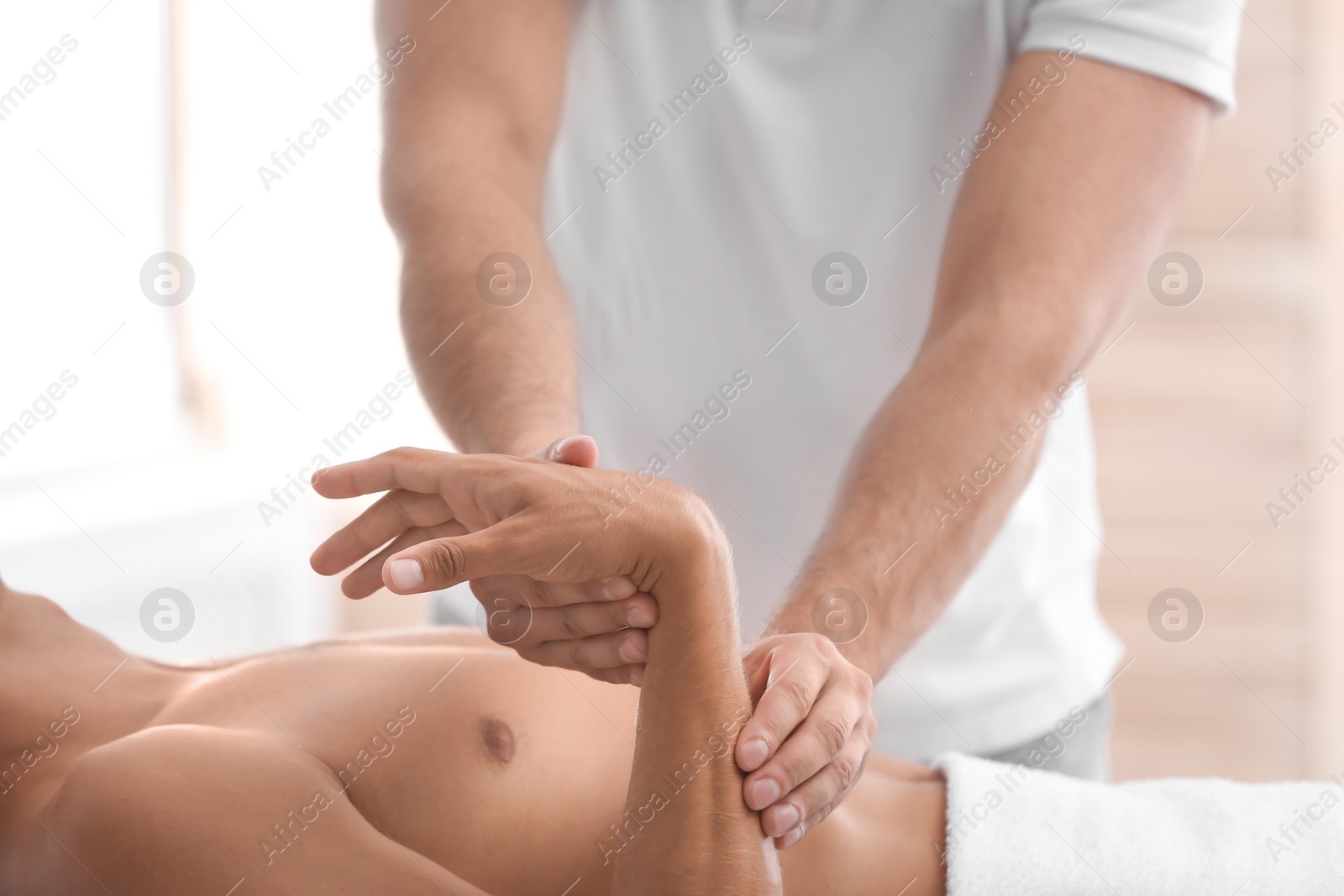 Photo of Young man receiving massage in salon, closeup