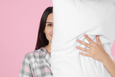 Photo of Young woman covering face with soft pillow on pink background