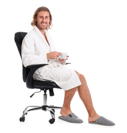 Photo of Young man in bathrobe with cup of drink on white background