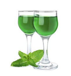 Photo of Delicious mint liqueur and fresh leaves on white background