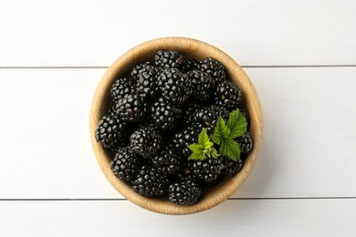 Photo of Bowl with fresh ripe blackberries on white wooden table, top view