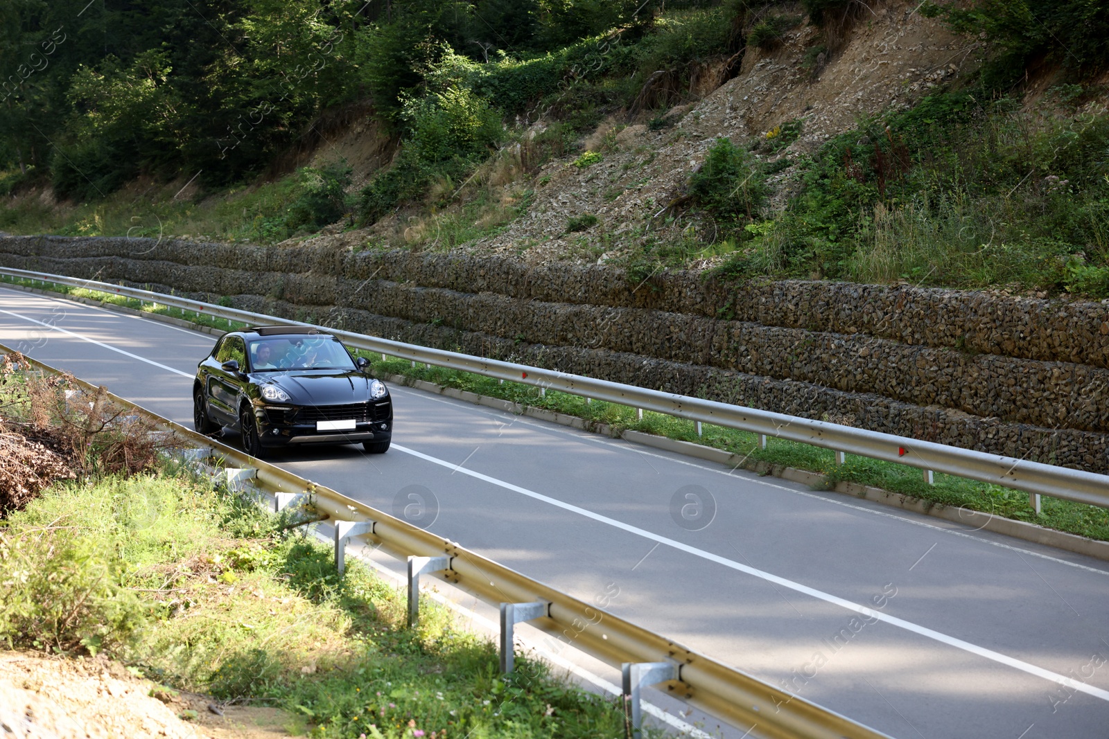 Photo of Picturesque view of asphalt road with modern black car outdoors