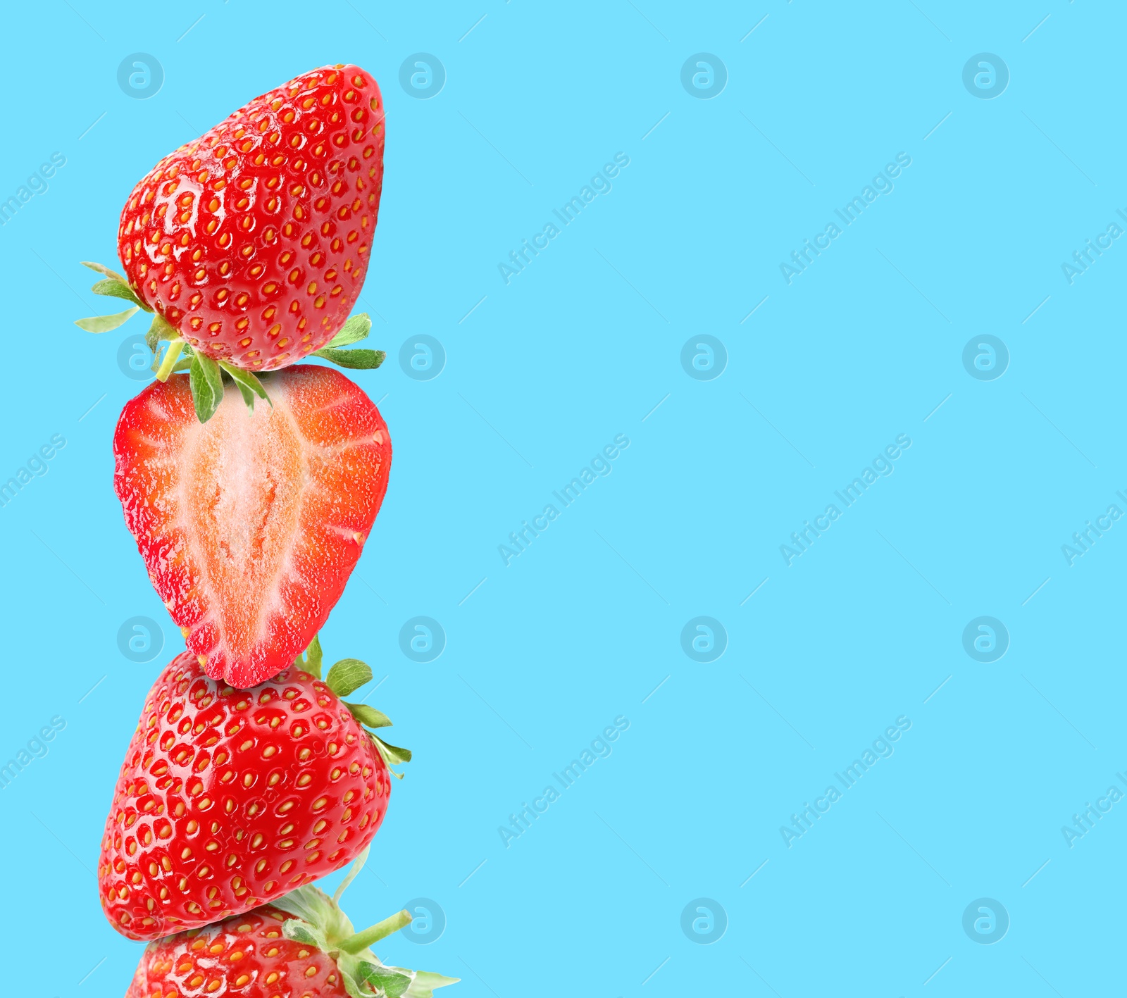 Image of Stack of fresh strawberries on light blue background, space for text