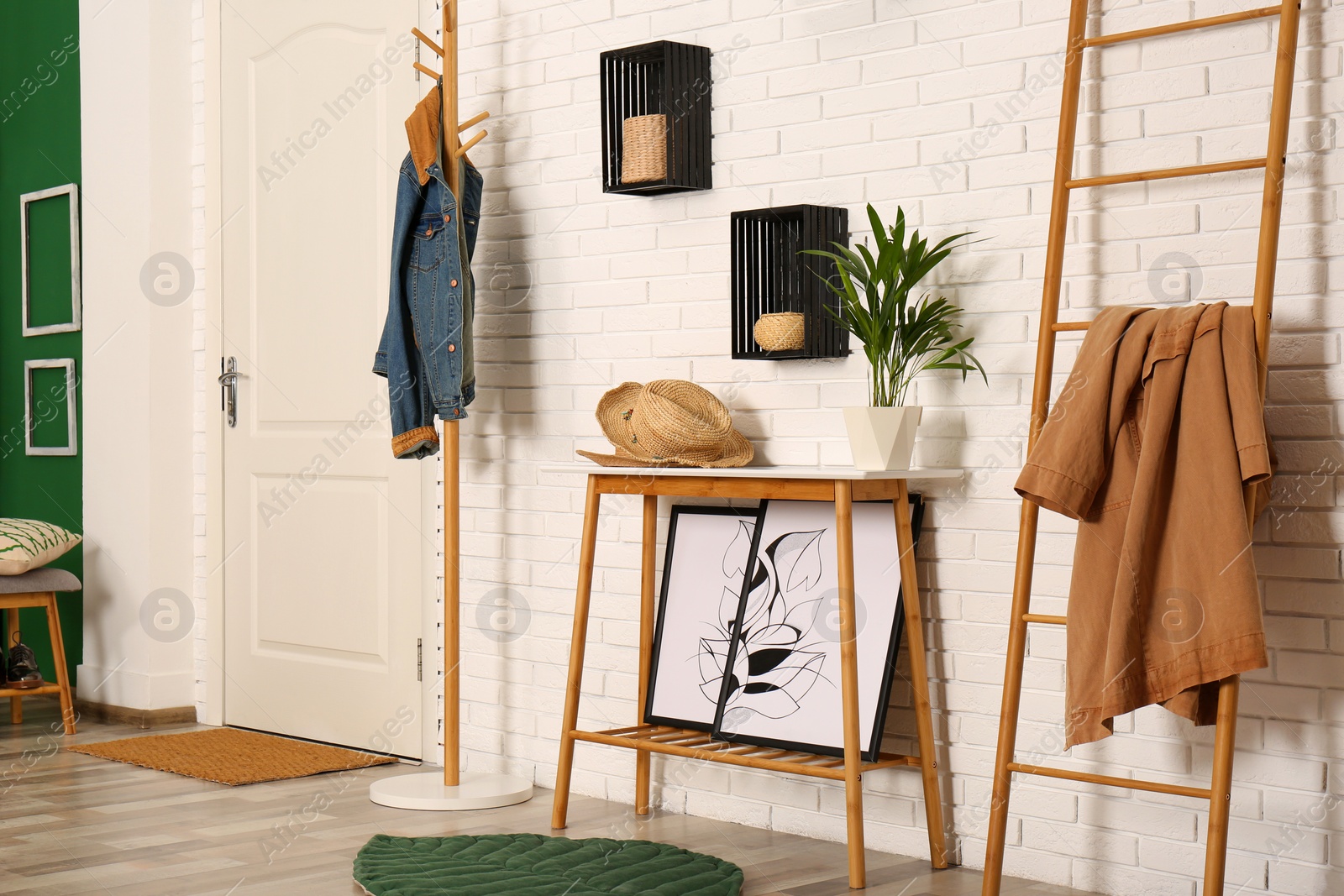 Photo of Stylish hallway interior with hanger stand, table and decorative wooden ladder