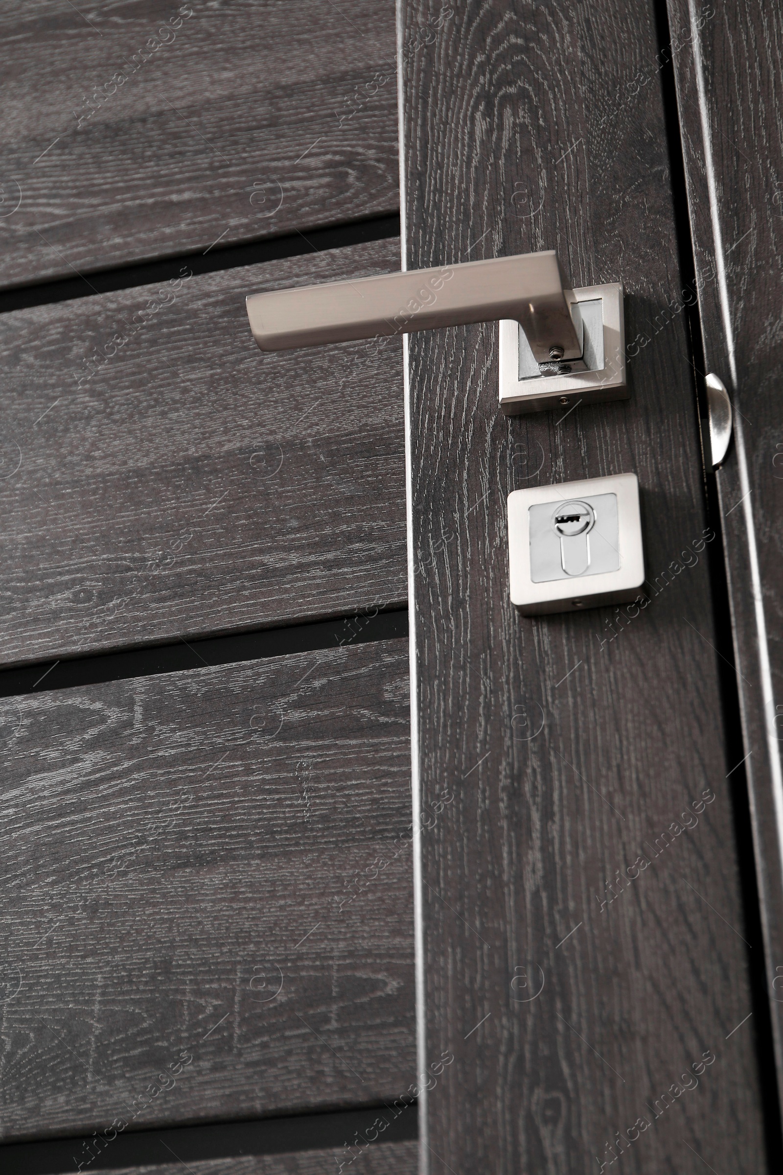 Photo of Dark wooden door with metal handle, low angle view